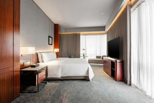 a hotel room with a bed and a television at St Giles Mid Valley Kuala Lumpur in Kuala Lumpur