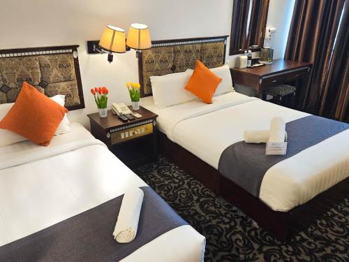 a hotel room with two beds with orange pillows at Swing & Pillows - Bandar Kuantan in Kuantan