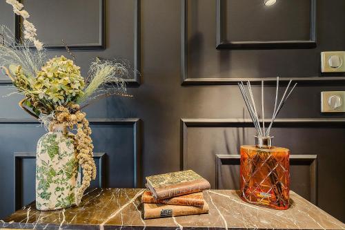two vases sitting on top of a table with books at Maison Saint Lazare in Vernon