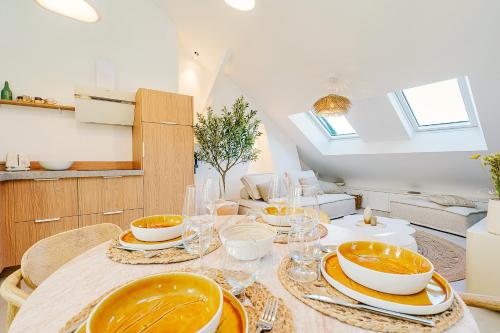 a dining room with a table with plates and glasses at Maison Soleil Levant in Vernon