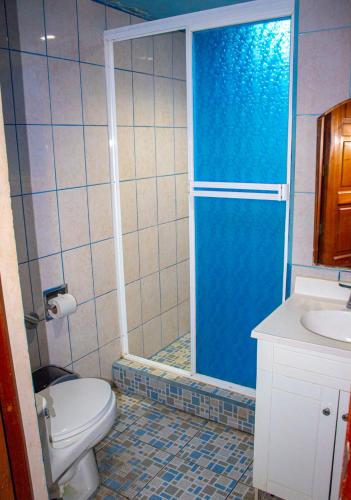 a bathroom with a shower with a toilet and a sink at Hotel HASA in Managua