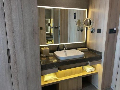 a bathroom with a sink and a mirror at Atour Hotel High Speed Railway North Station Zibo Hi tech Zone in Zibo