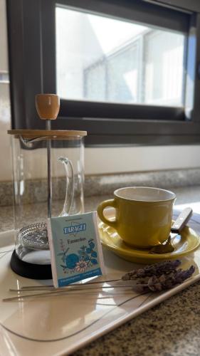 a plate with a coffee cup and a book on it at Pellegrini Apartments Mendoza !! Estupendos Departamentos con Cochera Privada cercanos a Parque Gral San Martin in Mendoza
