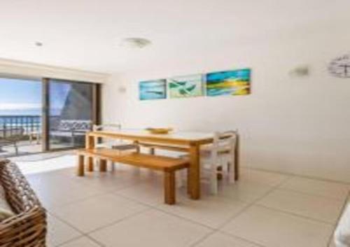 a dining room with a table and a bench at The Rocks Resort Unit 3C in Gold Coast