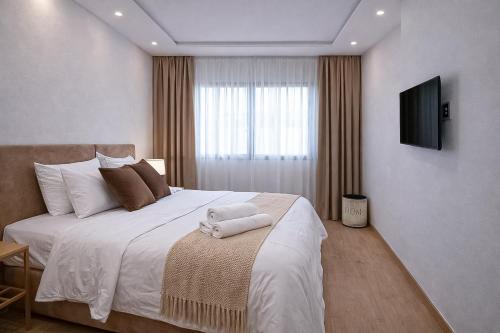 a bedroom with a large bed with a television on the wall at Affordable Luxury Apartment in Nouaseur