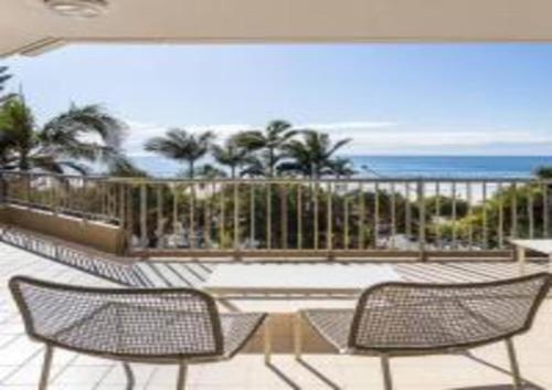a balcony with two chairs and a view of the ocean at The Rocks Resort Unit 3C in Gold Coast