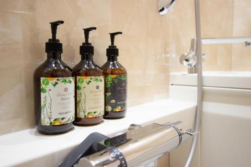 three bottles of wine sitting on a counter in a bathroom at Fam Hotel Imaizumi in Fukuoka