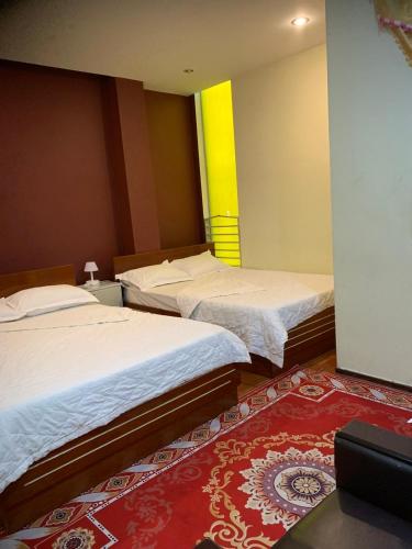 a room with two beds and a red carpet at Hotel Tài Phát in Can Tho