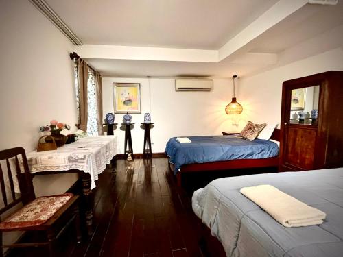 a bedroom with two beds and a table and chairs at Mận Đào Villa in Ho Chi Minh City