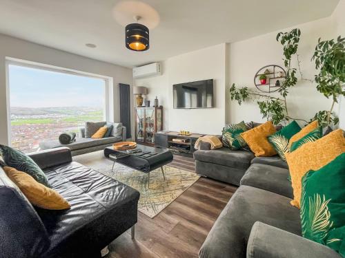 a living room with couches and a large window at Sea-Scape in Penrhyn Bay