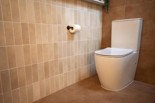 a bathroom with a toilet and a roll of toilet paper at Pacific Sun Bargara in Bargara
