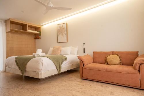 a bedroom with a bed and a couch at Pacific Sun Bargara in Bargara