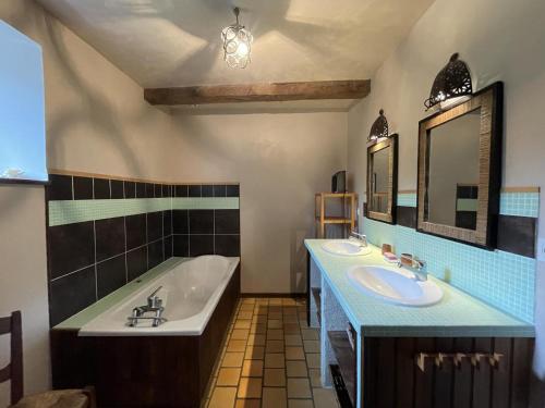 a bathroom with two sinks and a bath tub at Maison poumarou in Sainte-Colome