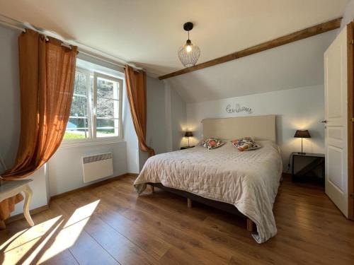 a bedroom with a bed and a large window at Peyre in Aramits