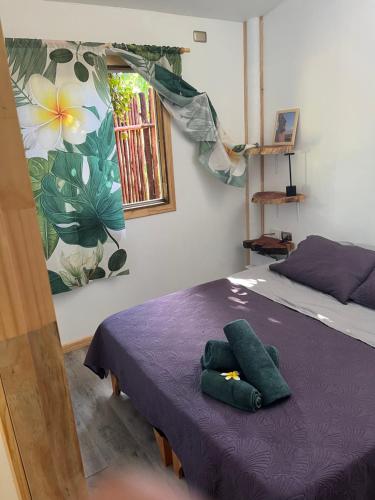 a bedroom with a purple bed with a window at Cabaña Rei miro in Hanga Roa
