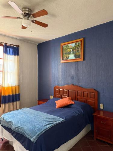 a bedroom with a bed and a ceiling fan at Casa Refugio Budget House 8 Rooms & 9 Bathrooms in Oaxaca City
