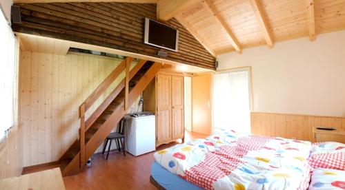 ein Schlafzimmer mit einem Bett und einer Treppe in der Unterkunft Chalet Abendruh in Grengiols