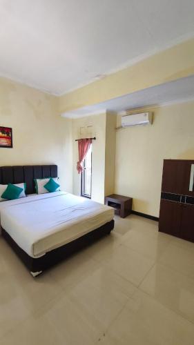a bedroom with a large bed and a window at Homely Guest House Tegal in Tegal