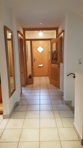 a hallway with a wooden door and a tile floor at Haus Aschenwald in Kitzbühel