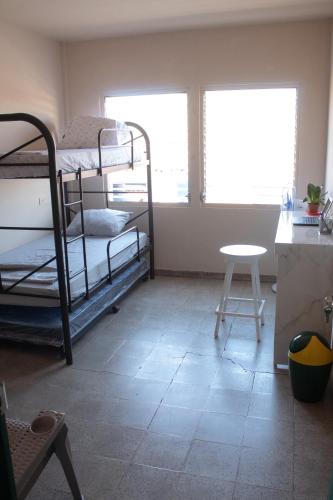 pokój z łóżkami piętrowymi, stołem i oknem w obiekcie Yek Hostels w mieście Santa Ana