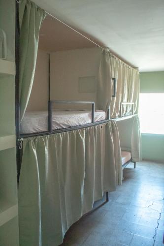 dwa łóżka piętrowe w pokoju z zasłonami w obiekcie Yek Hostels w mieście Santa Ana