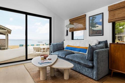 a living room with a couch and a table at Newly Remodeled Bayview Cabin 6! in Traverse City