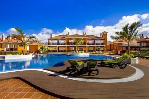 a swimming pool with chairs and a house at Selena Luxury Monte Carrera in La Playa de Arguineguín