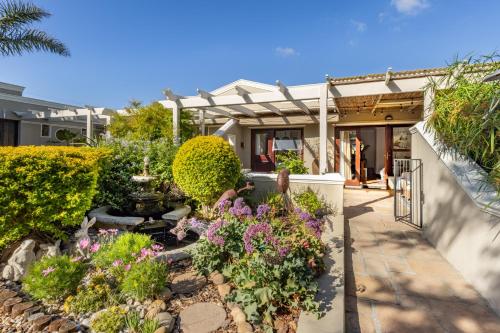 a garden in front of a house with flowers at Kaya La Provence in Cape Town