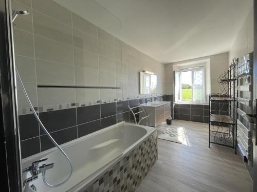a large bathroom with a tub and a sink at Gite du coos in Audaux