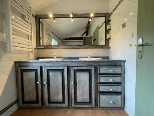 a bathroom with two sinks and a large mirror at Chez file in Séméacq-Blachon