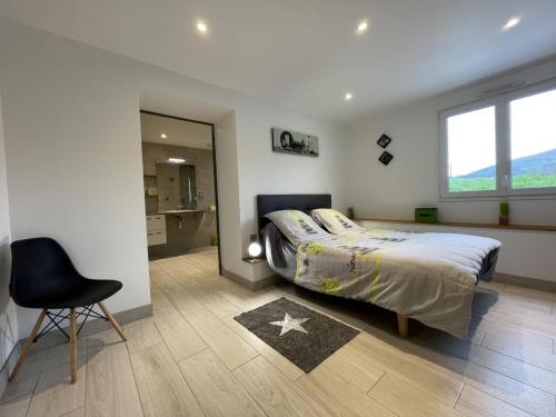 a bedroom with a bed and a chair and a mirror at Eki-begia in Ainhice-Mongelos
