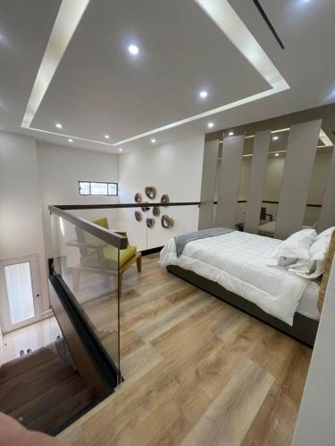a bedroom with a large bed and a glass staircase at Bello Departamento in Mexicali