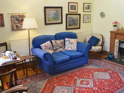 a blue couch in a living room with a table at The Stable in Hastingleigh