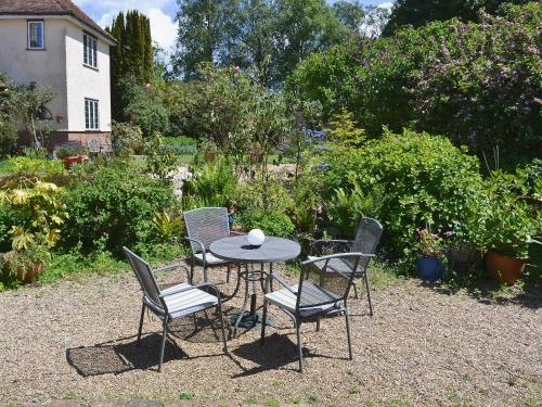 a table and chairs sitting in a garden at The Stable in Hastingleigh