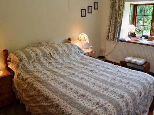 a bedroom with a bed and a window at The Stable in Hastingleigh