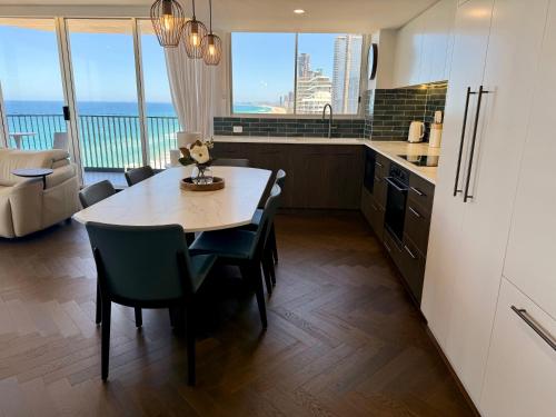 a kitchen with a table and chairs with a view of the ocean at Golden Sands on the Beach - Absolute Beachfront Apartments in Gold Coast