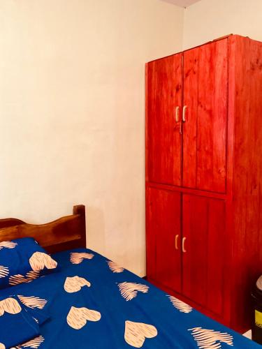 a bedroom with a bed and a red cabinet at PG Vacation Rental in Lapu Lapu City