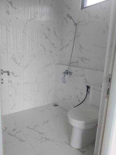 a white bathroom with a toilet and a shower at Mroom Villa Cipanas in Pacet