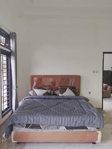 a bedroom with a large bed with a blue comforter at Mroom Villa Cipanas in Pacet