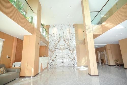 a lobby with a large marble wall in the middle at VELIN Pattaya Hotel in Pattaya