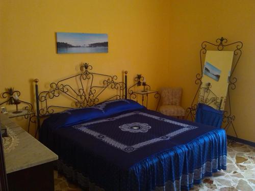 um quarto com uma cama com um cobertor azul em Happy House Wifi Free Bici Free em Avola