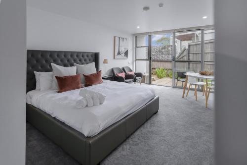 a bedroom with a large bed and a living room at Bay View Sunrise in Lorne