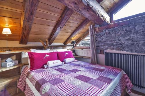 a bedroom with a purple bed in a wooden room at Majon Samuel in Courmayeur