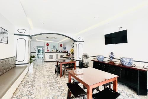 a living room with a table and a kitchen at Peranakan Boutique Hotel - SHA Plus in Phuket