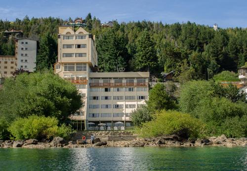 a large building on the side of a river at Patagonia Hotel in San Carlos de Bariloche