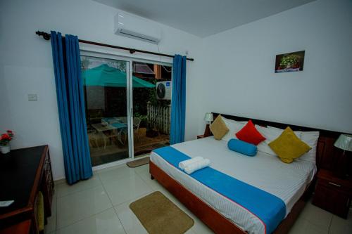 a bedroom with a bed with colorful pillows and a window at Meth Suites in Epamulla