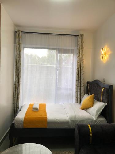 a bedroom with a bed in front of a window at Thesh Home at Tsavo Sunset 2 ,Thindigua Kiambu Road in Kiambu