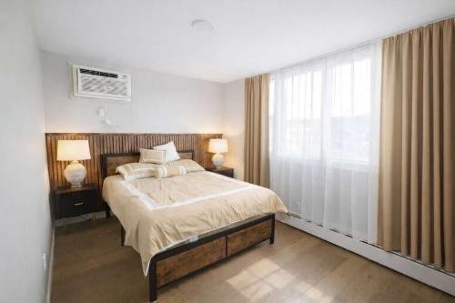 a bedroom with a bed and a large window at Jefferson Sr - 20 mins to Manhattan, NYC in West New York