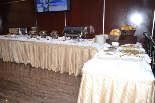 a long table with white table cloths and plates of food at Noubou International Hotel in Douala