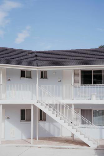 a white building with a staircase in front of it at Motel Molly - Boutique Hotel Mollymook in Mollymook